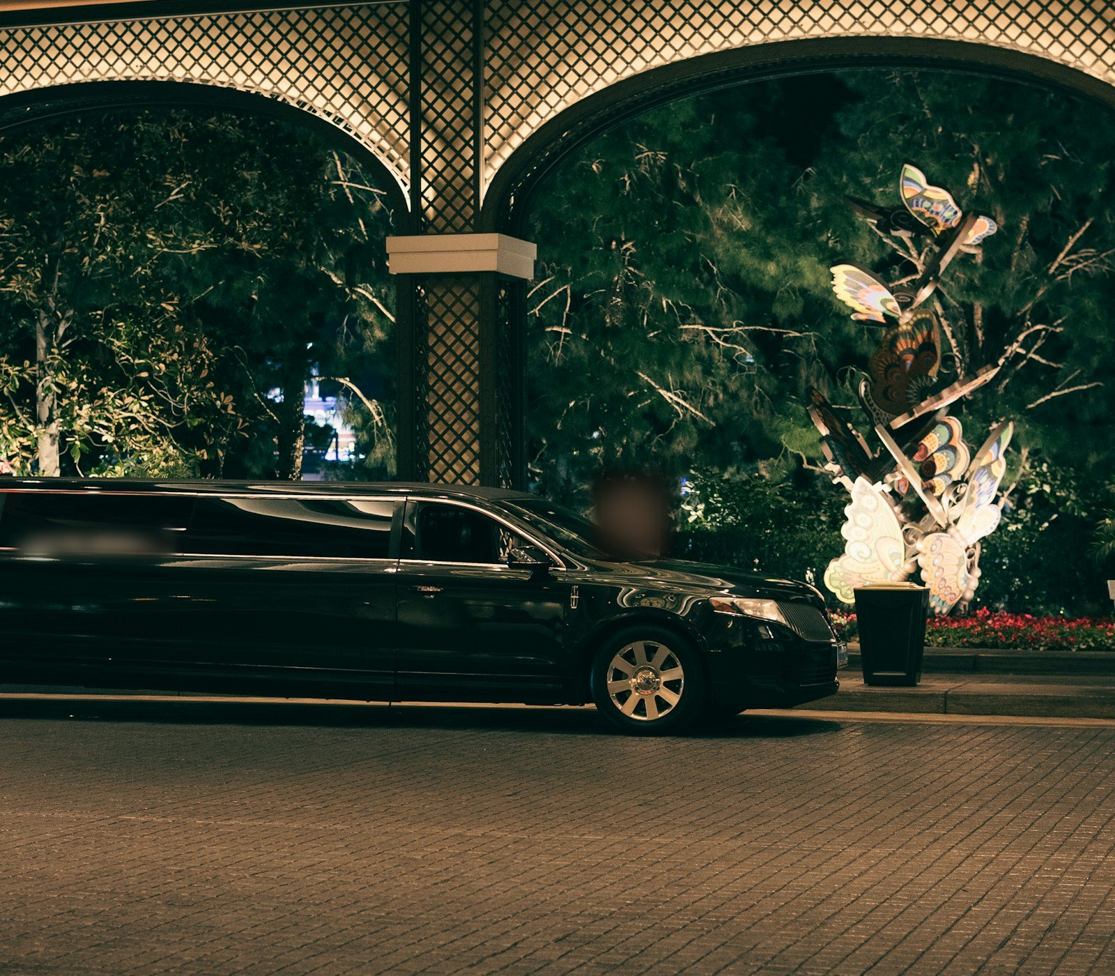 Sort limousine foran oplyste buer om natten